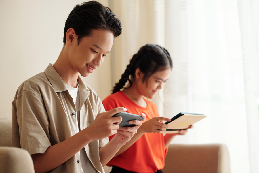 Male-and-female-Asian-teen-play-on-ipad-tablets