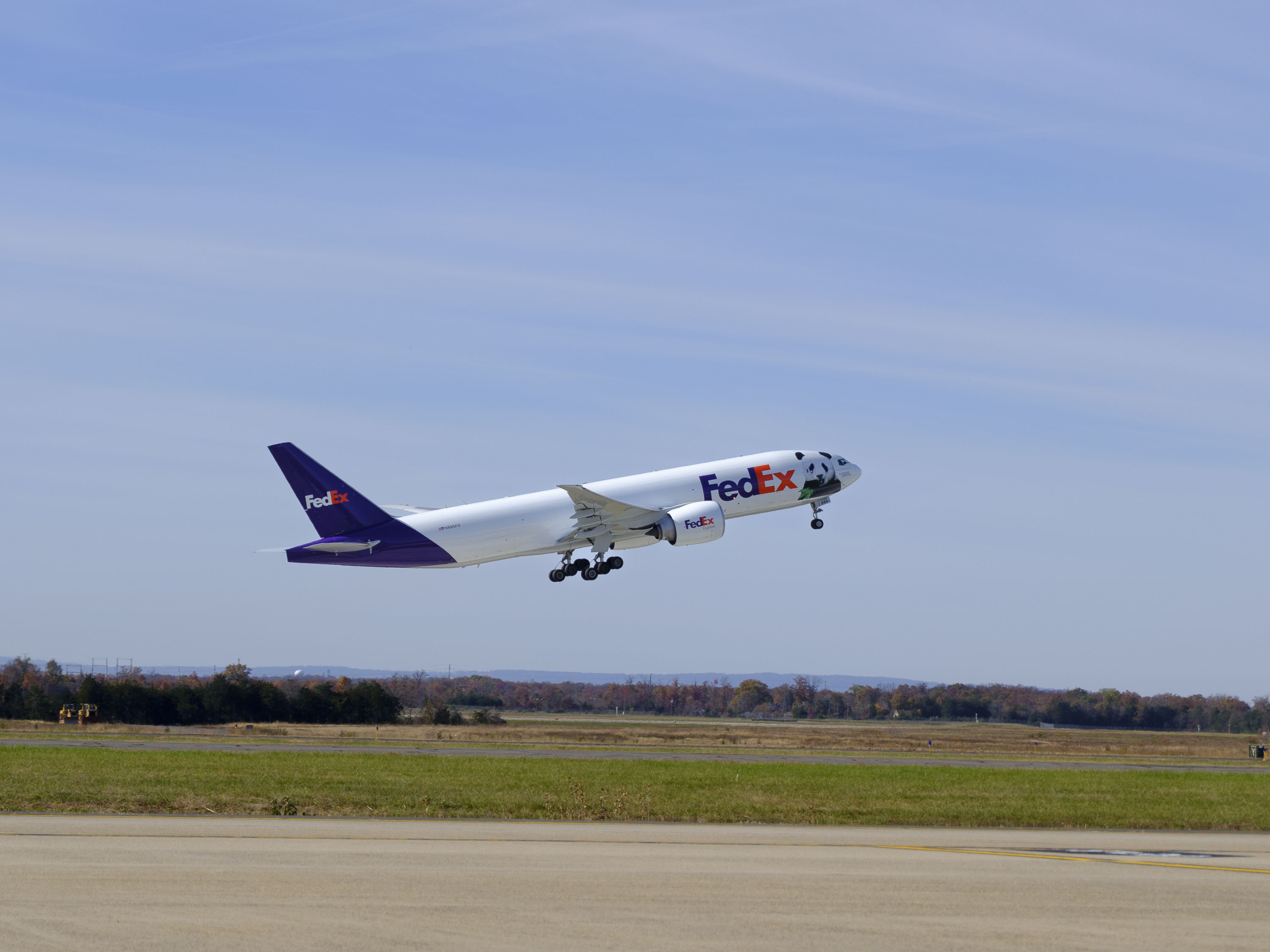 FedEx Panda Express 777 plane taking off at airport