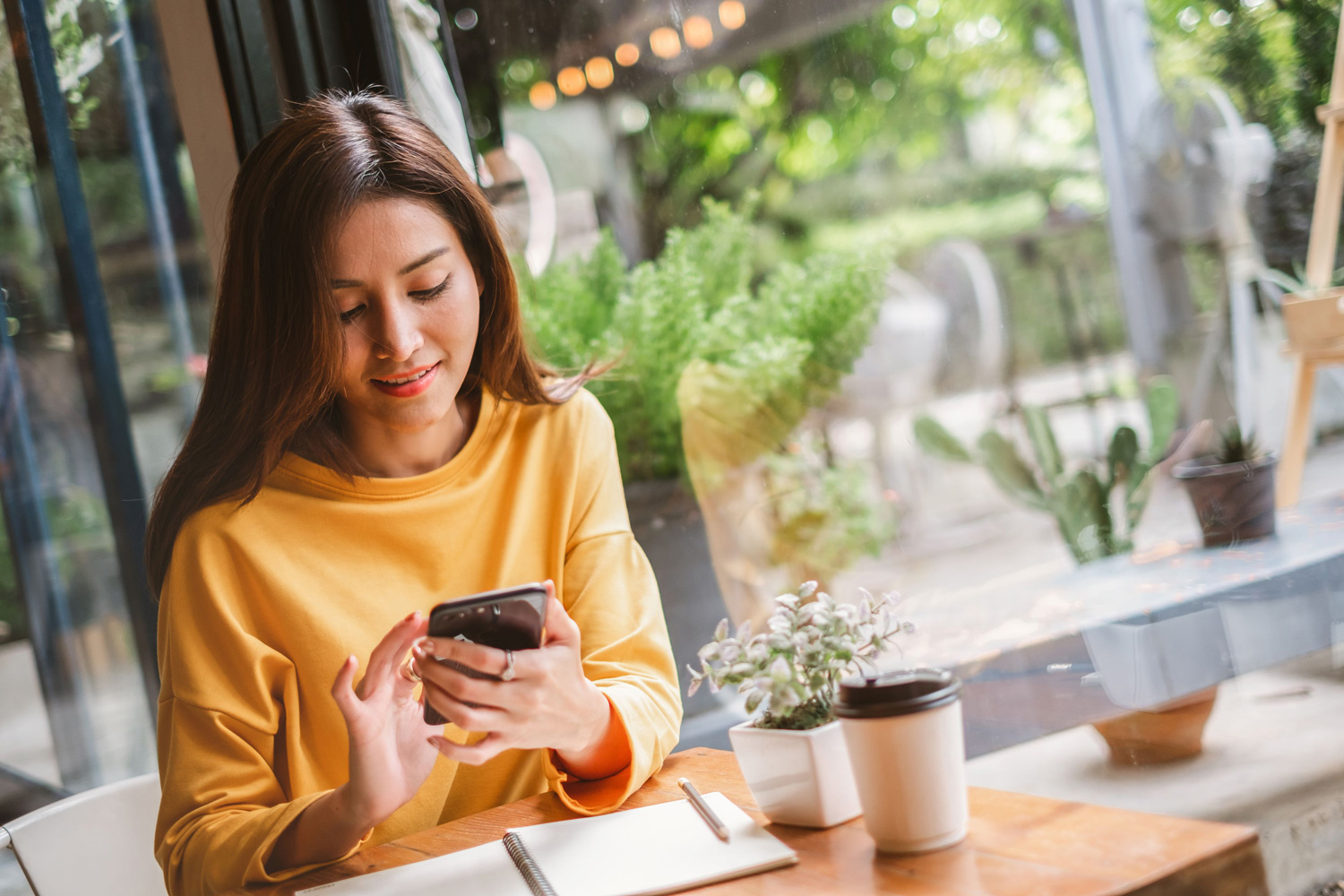 Female remote worker using phone with coffee