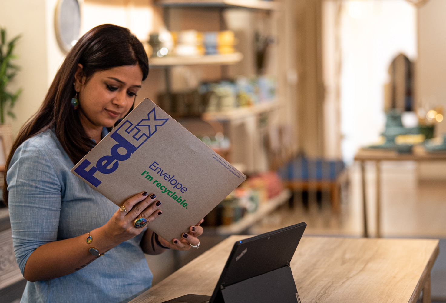 Indian female examines FedEx Reusable Pak flat parcel