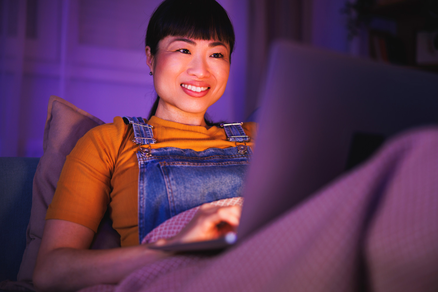 A woman uses a laptop at home late at night