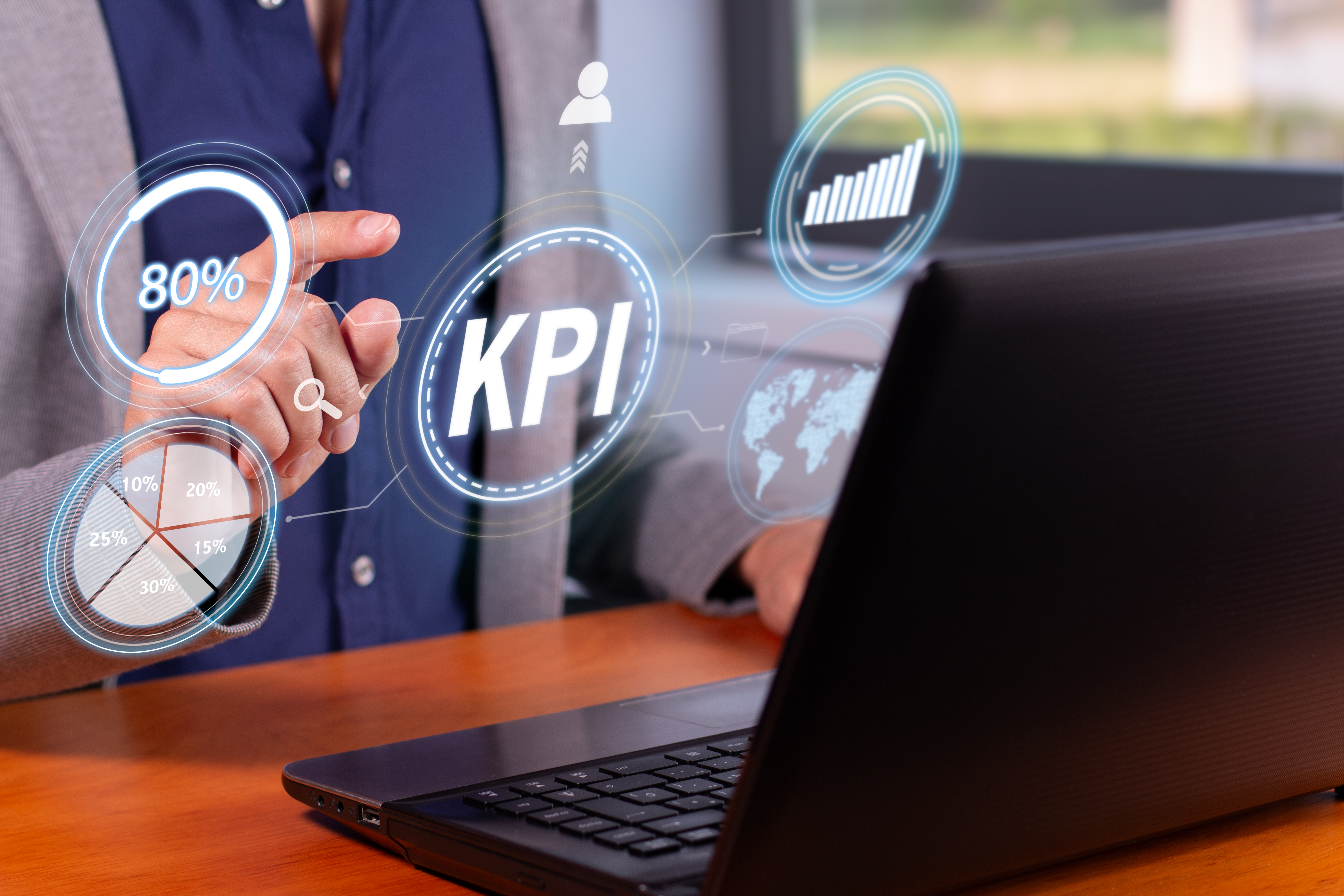 A man working on a laptop with KPI icons and charts displayed in front of him