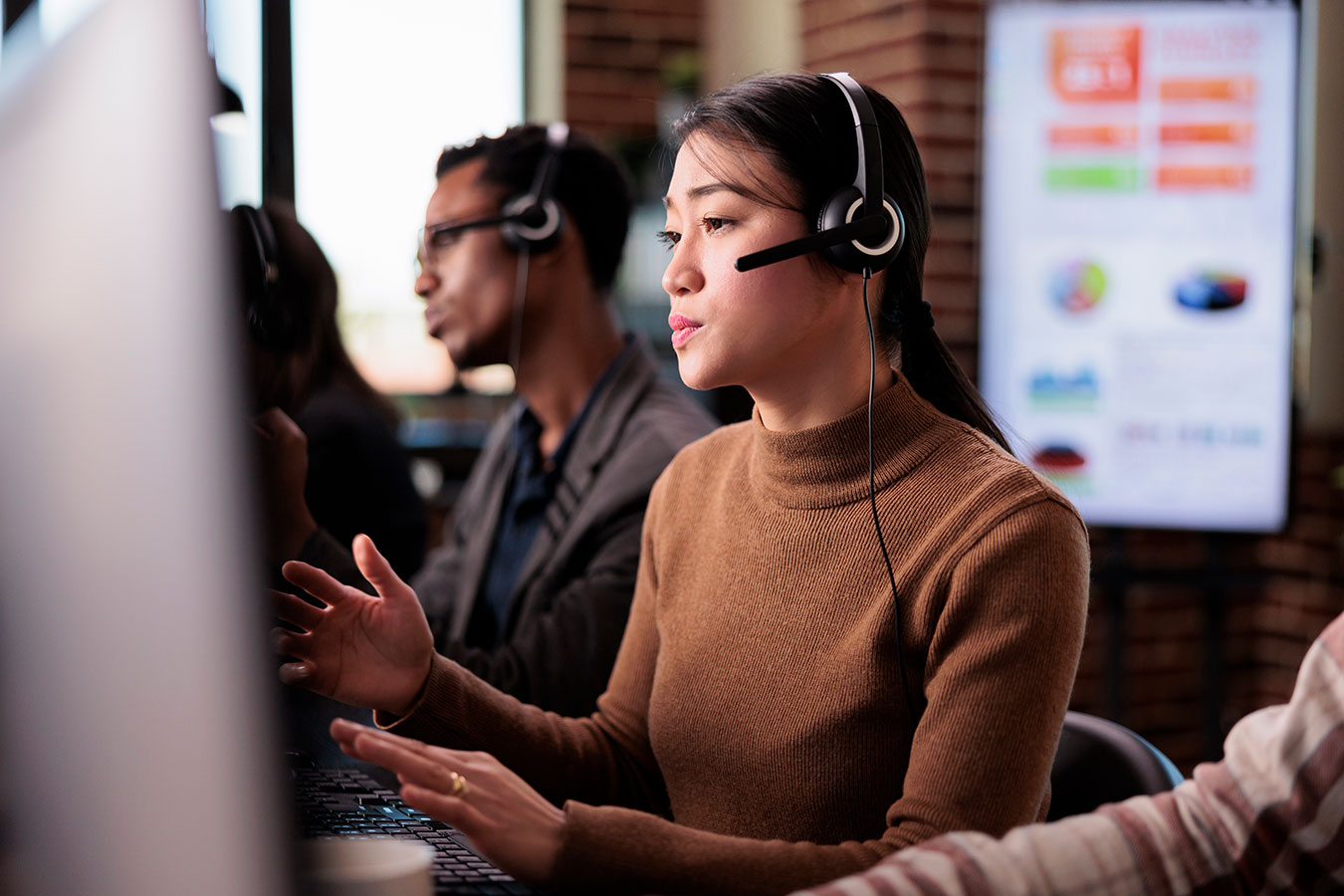 Asian female receptionist with headset working at call center