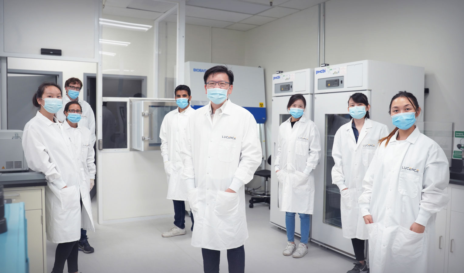 Group of Asian medical professionals in white lab coats and surgical masks