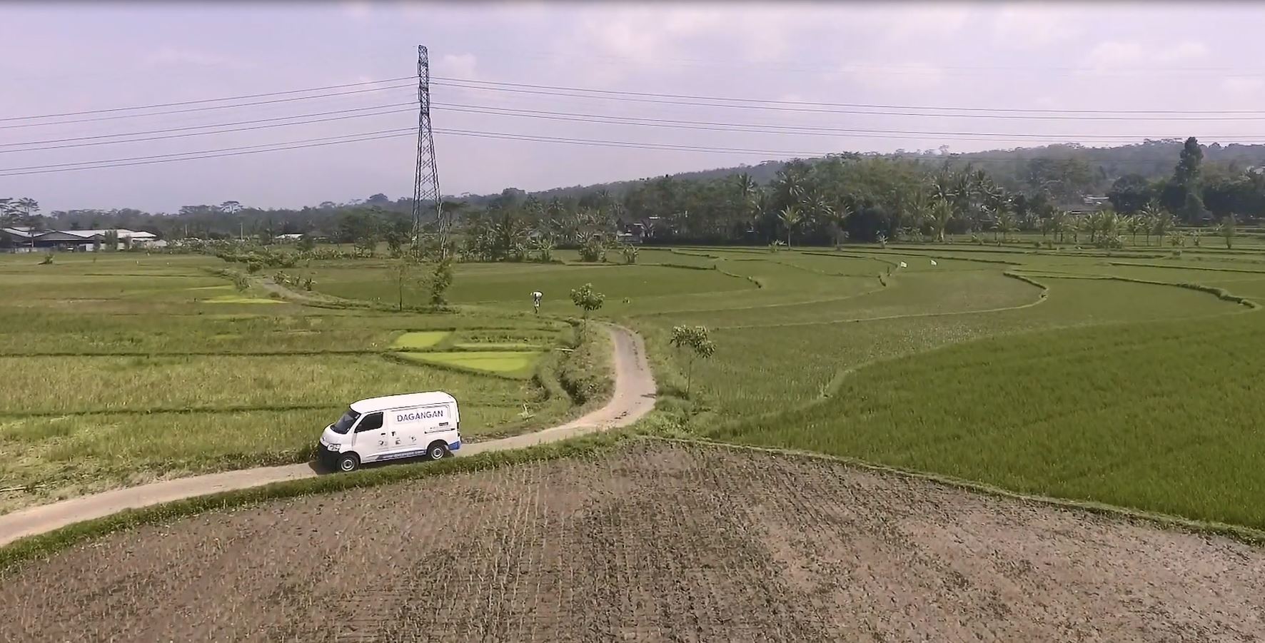 White Dagangan-branded van driving through remote countryside