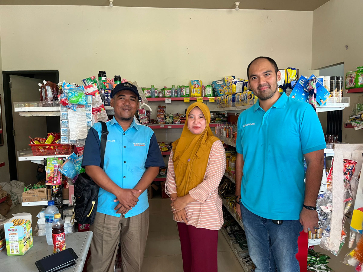 Ryan Manafe, CEO of Dagangan, with a male Dagangan employee and a female rural shopkeeper