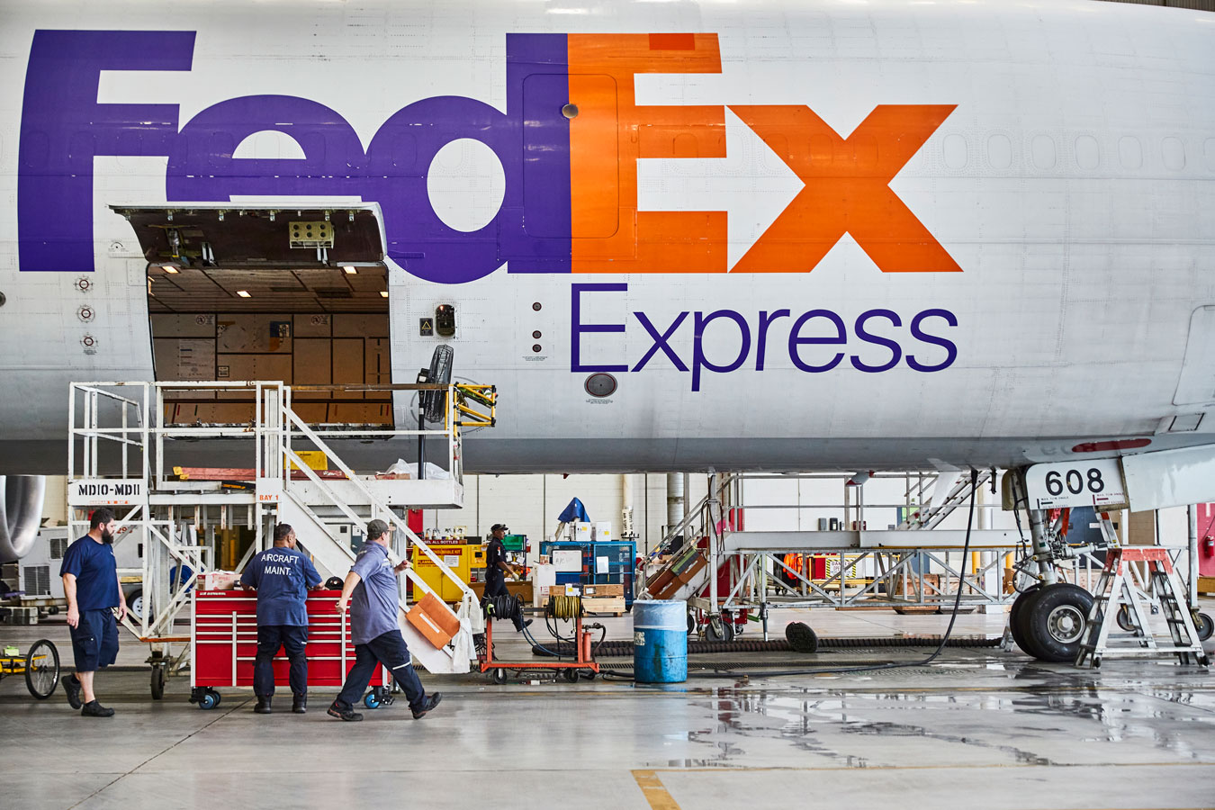 FedEx Express plane in airport hangar with cargo loaded using steps