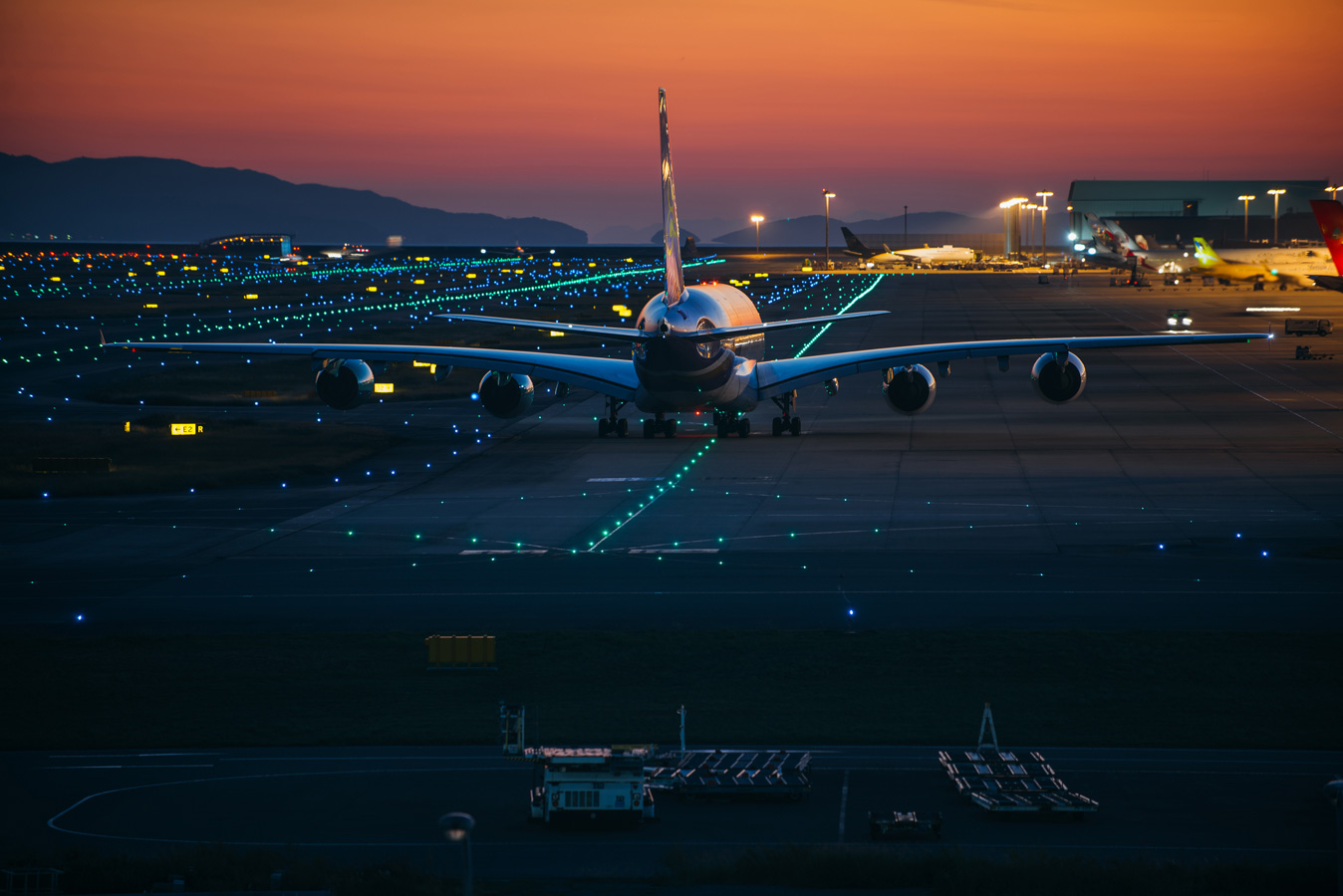 Plane on airport runway tarmac at sunset