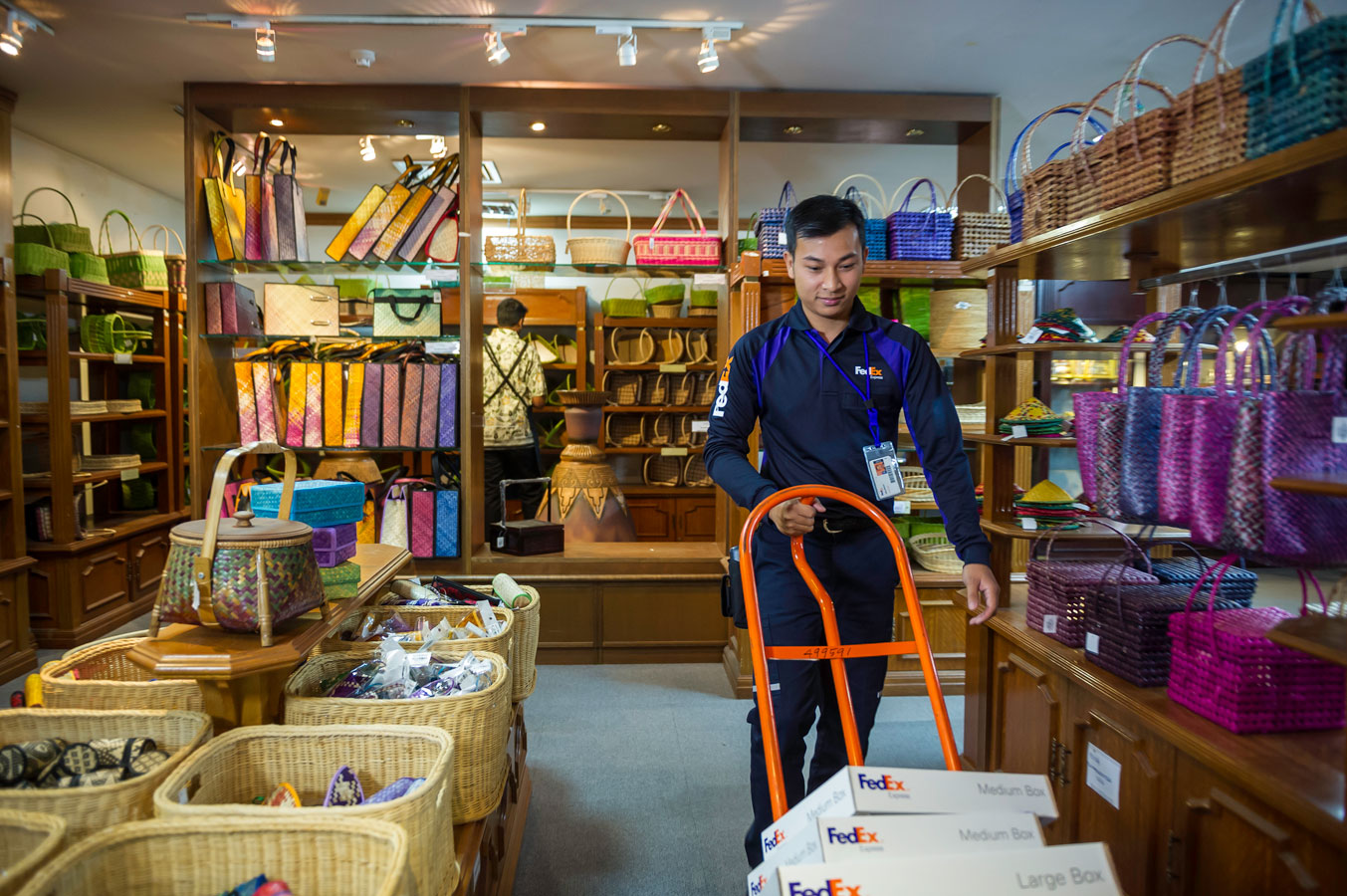 A FedEx employee delivers packages in a shop.