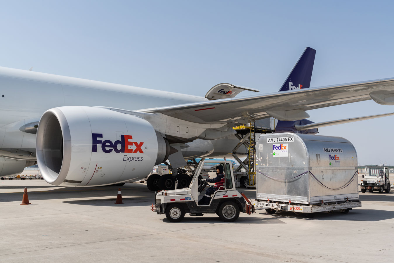 FedEx plane on tarmac being loaded with cargo at airport