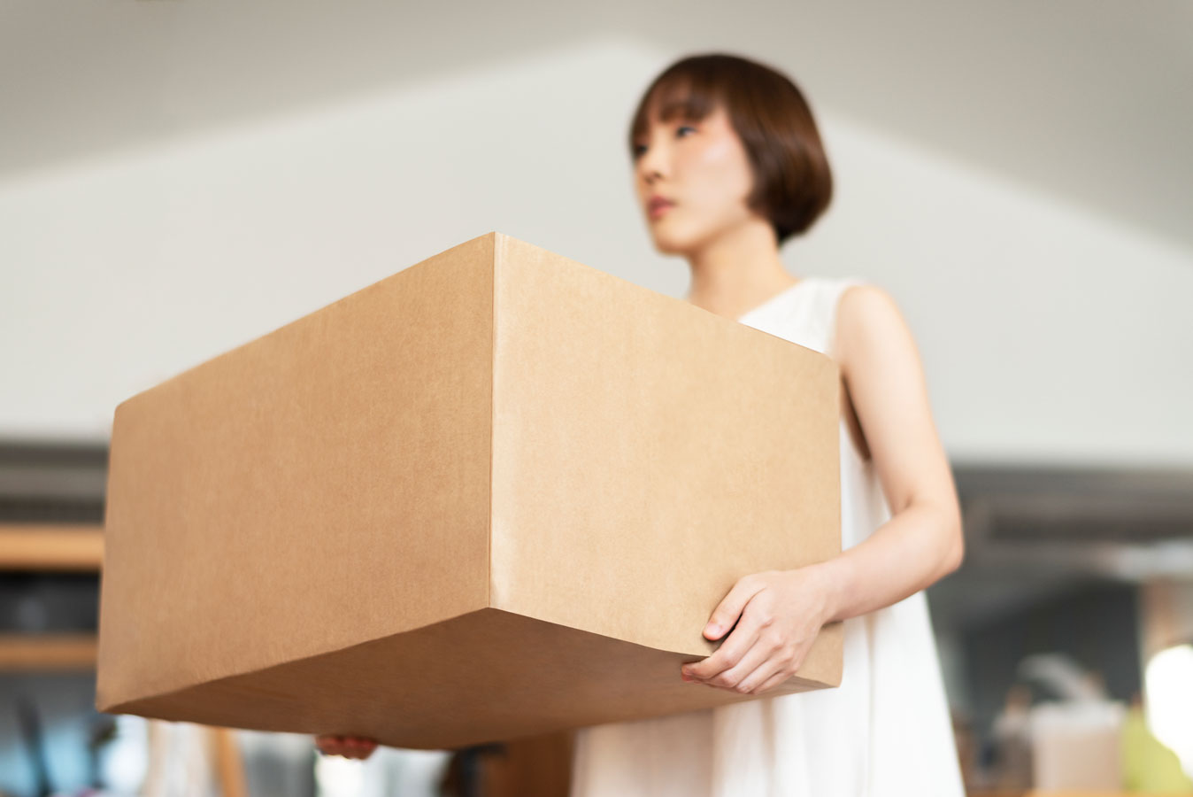 Asian female carries large box