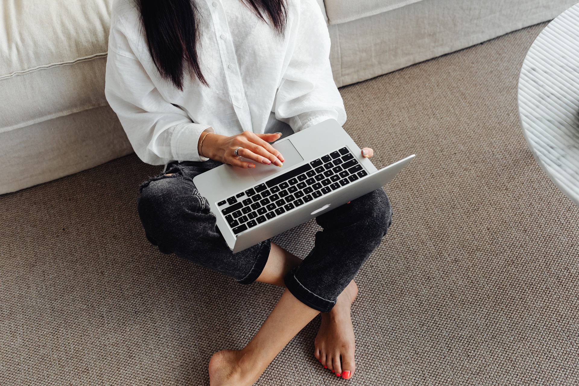 Young Asian woman sits in living room using a laptop